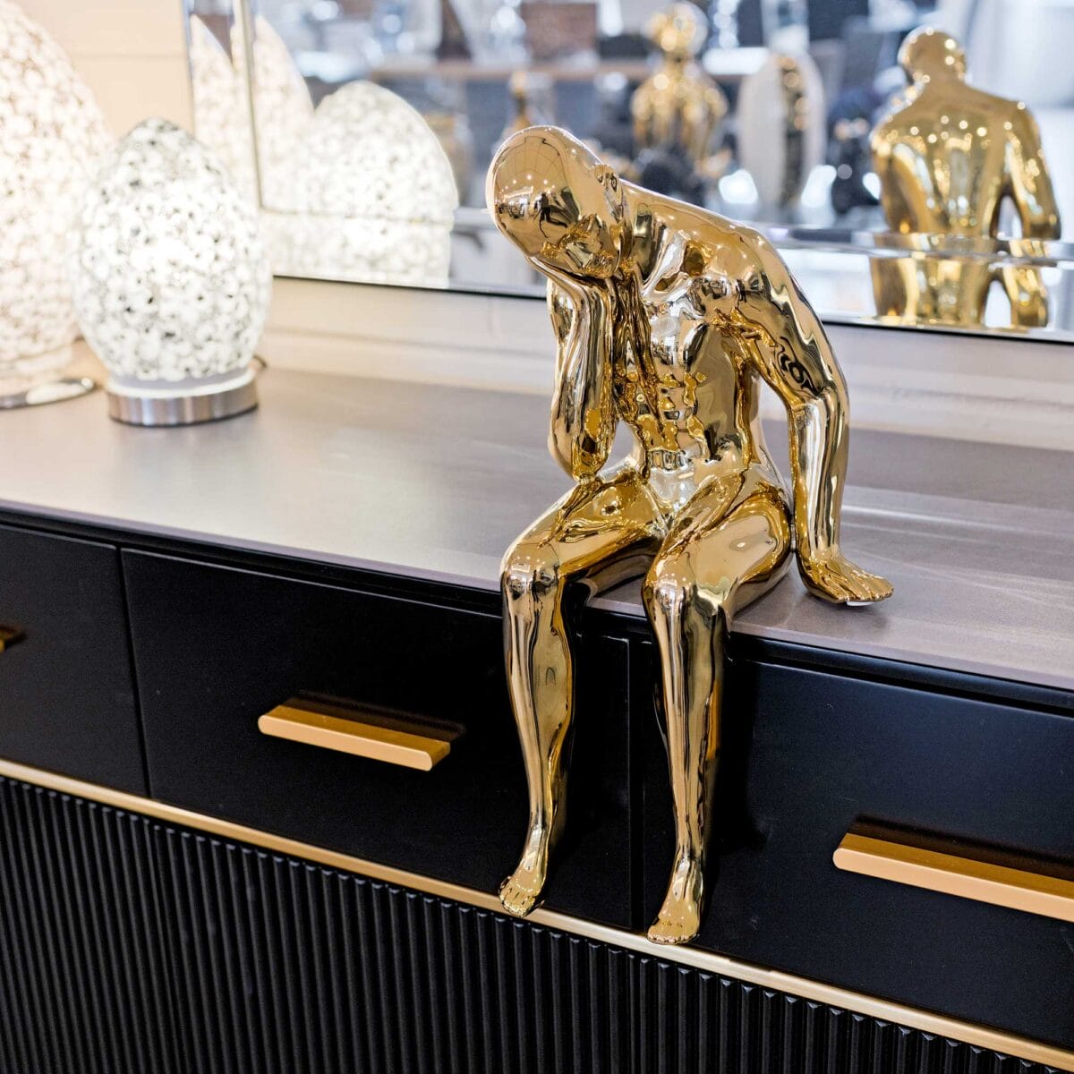 Ceramic gold thinking man on display