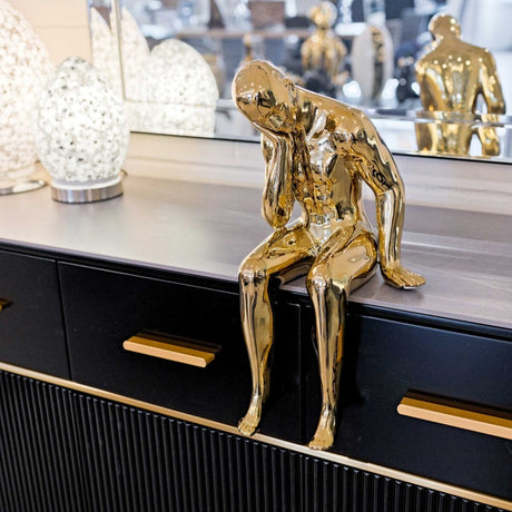 Ceramic gold thinking man on display